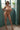 Naked person standing in a room with a window and plant