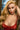 A highly realistic light tan sex doll with long blonde hair and a red dress, posed with a gentle expression.