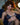 Woman in a patterned bikini sitting on a couch with a plant in the background