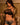 Woman in black bra and shorts with a gold jacket in a room setting