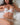Woman wearing white lace lingerie on a bed