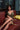 Woman in a gold dress sitting on a red couch with a blurred background
