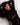 Woman in a black outfit lying on a white textured surface