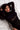 Woman in a black outfit lying on a white textured surface