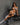 A highly realistic sex doll on a black bench.