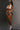 A highly realistic sex doll standing wearing only panty.
