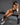 A highly realistic sex doll sitting on a black bench in nude.