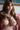 Asian model in pink lingerie sitting on bed