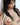 Topless Asian woman with hand covering chest