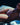 Partial nude body lying on a dark surface with light filtering through.