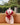 Mannequin wearing a red bikini on a beige couch outdoors.