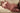 Naked person lying on a couch with a neutral background