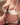 Person wearing a white lace bra and panties set on a neutral background