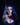 Person with blue hair and horns wearing a blue dress against a black background