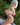 Person wearing a white bikini outdoors with greenery in the background