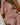 Partial nude image of a person sitting on a chair.