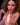 Sexualized figurine of a woman holding a large object, with visible branding.