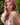 Woman with pink hair and a light dress in a natural setting