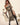 Woman in a costume holding a sword on a neutral background