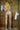 Person standing in a shower with tiled walls and a towel rack.