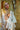 Person wearing a white robe in front of a shower with 'GalaTeardoll' branding.