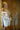 Sex doll in a white satin robe with a blurred background