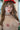 Partial nude figure with a red cap against a blurred natural background