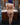 A sex doll with blue hair standing nude showing her back in a bathroom.