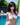 Person in a white bikini by a pool with greenery in the background