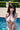 Person in a swimsuit by a pool with greenery in the background