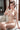 Naked person sitting indoors with a neutral background