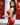 Woman in a red floral dress posing in front of a blurred background with Chinese characters.