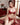Woman in a red lace lingerie set sitting on a carpeted floor.