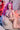 Person with pink hair sitting on a bean bag chair in a room with a poster in the background