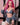 Person with pink hair wearing a denim outfit holding a book.