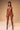 Naked woman standing against a beige background