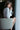 Woman sitting on a chair holding a glass of water indoors.