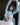 Woman in a white outfit sitting on a chair with a blurred background