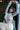 Woman in a white outfit sitting on a chair with a blurred background