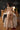 Naked person standing in a room with a lace tablecloth and furniture.