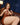 Highly realistic sex doll in brown dress on a sofa.