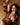 Highly realistic sex doll in brown dress on a sofa.
