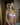 Woman wearing a pink bra and underwear set in a softly lit room.