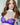 Person wearing a purple lace bra and silver choker with 'Nudist' branding.