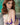 Person wearing a purple lingerie set with visible branding on a blurred background