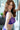 Woman wearing a purple lace lingerie set with a blurred background