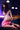 Person wearing a pink outfit with fishnet stockings in a dimly lit room.