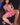 Sex doll in pink outfit with fishnet stockings on a dark surface