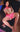 Sex doll in pink outfit with fishnet stockings on a dark surface
