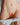 Partial view of a person wearing light-colored underwear indoors.